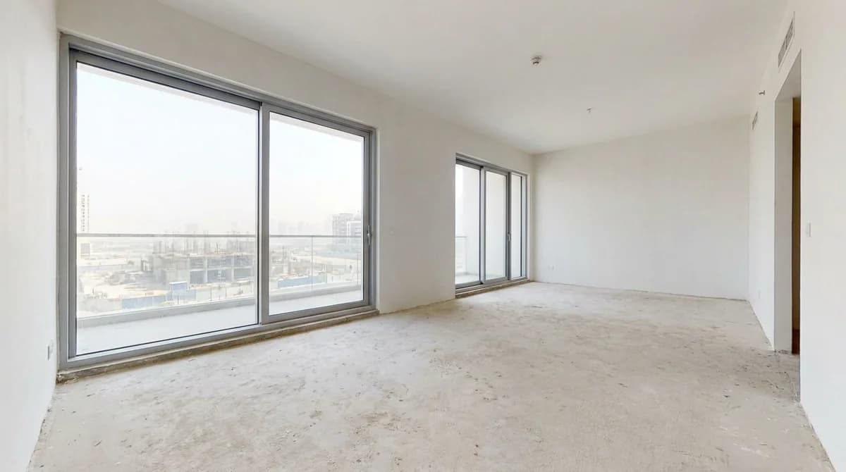 Empty unfurnished new-construction apartment with bare floor and floor-to-ceiling windows