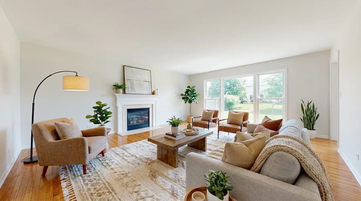Dasselbe Wohnzimmer nach dem virtuellen Staging mit AI, mit Sofa, Sesseln, Teppich und Bildern